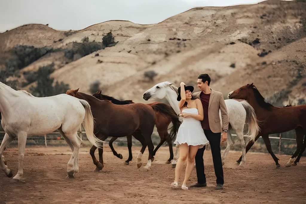 A couple with running horses in a Cappadocia valley